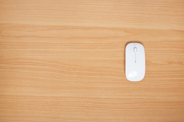 Wireless mouse for computer and laptop on wood background. top view. copy space.