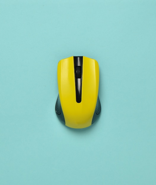 Wireless mouse isolated on a blue pastel background. Top view, minimalist trend