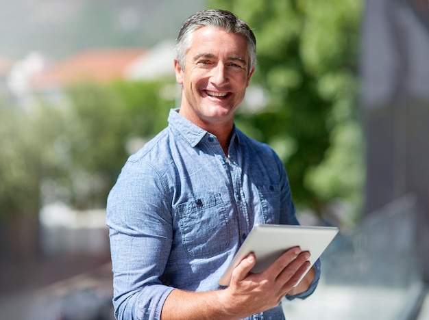 Wireless technology keeps my daily tasks streamlined Portrait of a casually dressed businessman using a digital tablet outside