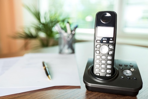 Photo wireless telephone on a wooden desk