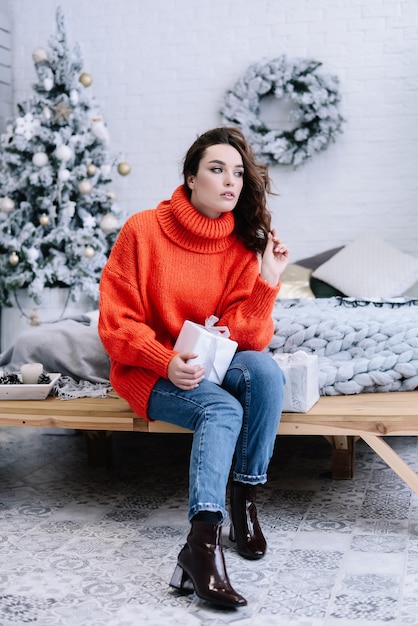 Wish you a Merry Christmas! Girl with a Christmas presents looking aside. Happy feeling to New Year. Christmas party!