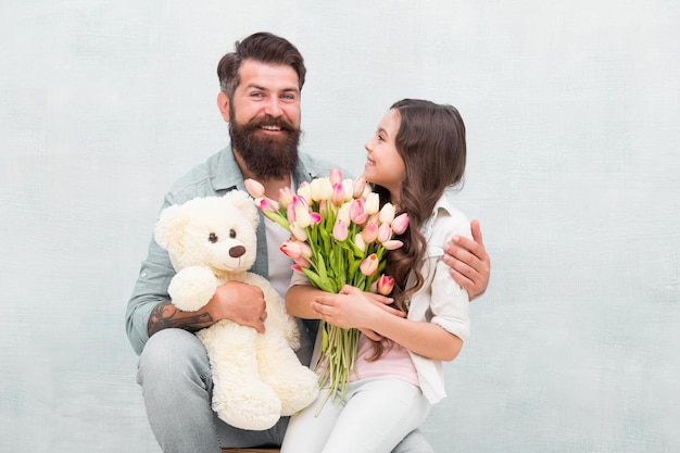 Wishing happy anniversary Happy family celebrate anniversary Father and daughter hold tulips and toy Fathers day Womens day Birthday anniversary Holiday celebration International childrens day