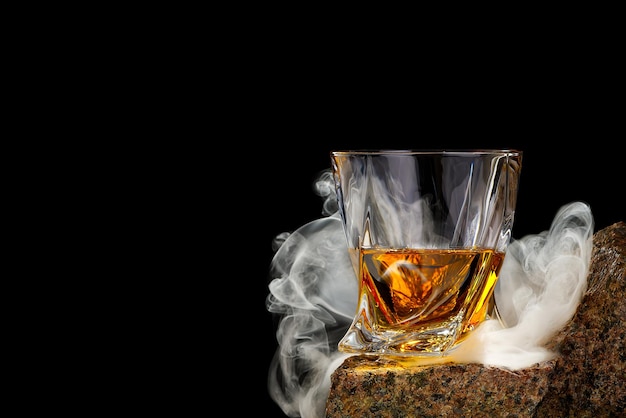 Wisky vetro sulla roccia su sfondo nero wisky vetro senza ghiaccio