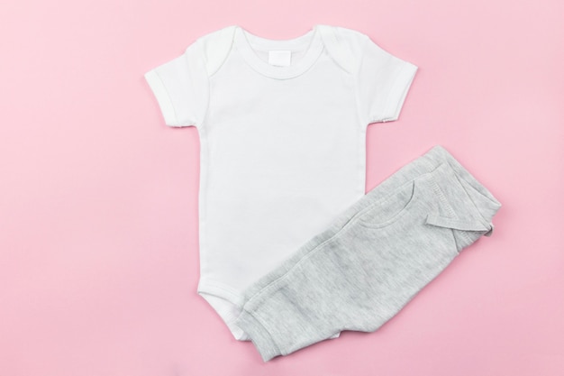 Wit babymeisje bodysuit mockup plat lag met grijs slipje op het roze oppervlak