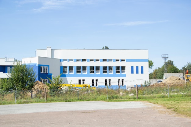 Wit blauw gebouw van het sportcomplex in aanbouw in de zomer