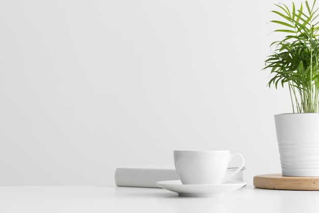 Wit boek kopje koffie en een palm in een pot op een witte tafel Plat gelegd met lege kopieerruimte