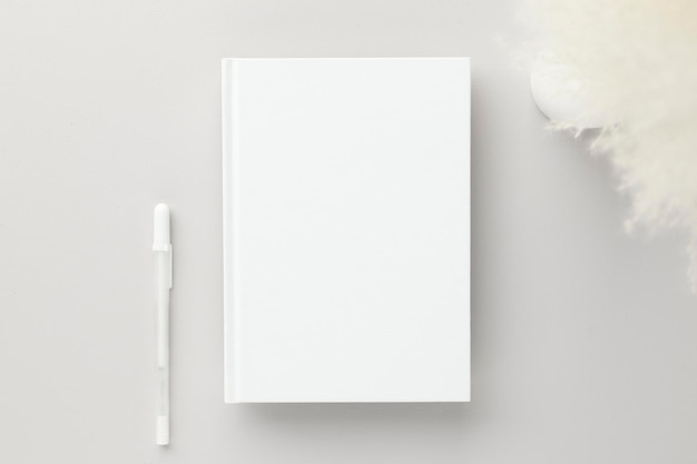 Wit boek lege omslag mockup op een beige achtergrond met droge bloem plat lag mockupxA