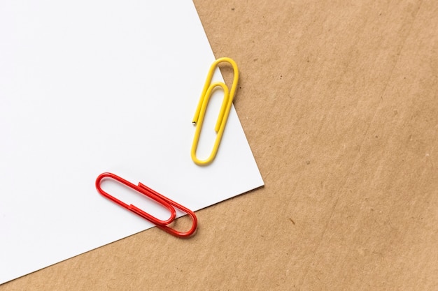 Wit briefhoofd en gekleurde paperclips op kraftpapier-achtergrond