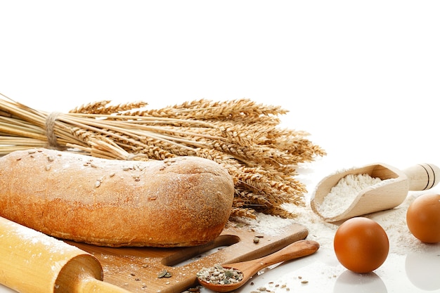 Wit brood en kookgerei geïsoleerd op een witte tafel