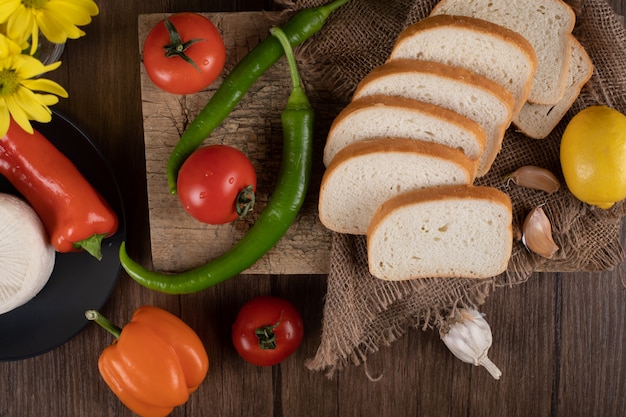 Wit brood met rode tomaten en groene pepers