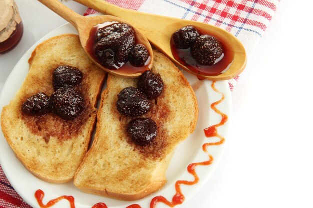 Wit brood toast met jam op plaat geïsoleerd op wit