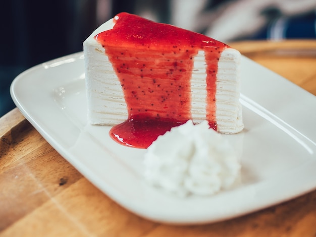 Foto wit crêpe cake met rode aardbeienjam.