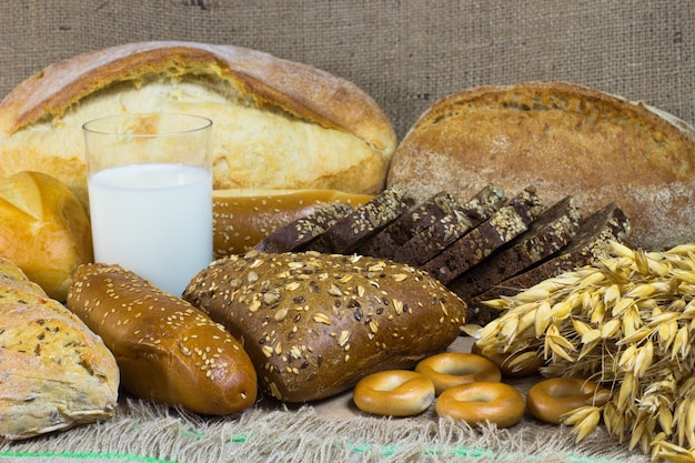 Wit en zwart brood, stokbrood, broodje, een bosje haver, glas melk bij het ontslaan