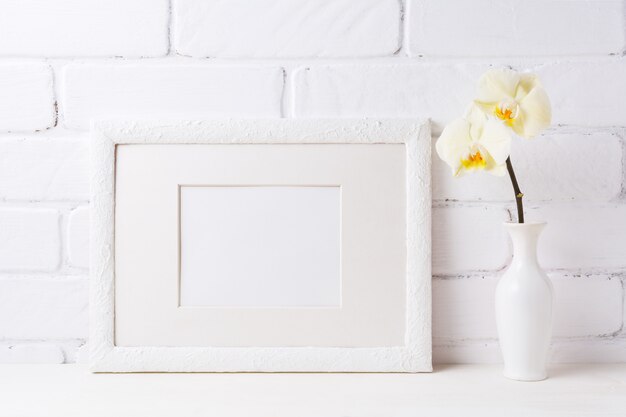 Wit frame mockup met zachtgele orchidee in vaas