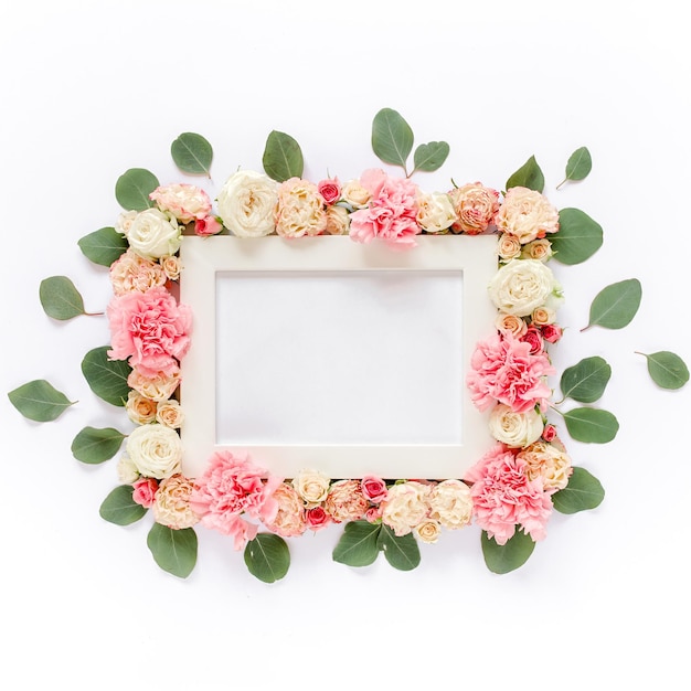 Wit frame versierd met roze rozen bloemen en bladeren van eucalyptus plat lag bovenaanzicht bloemen rug