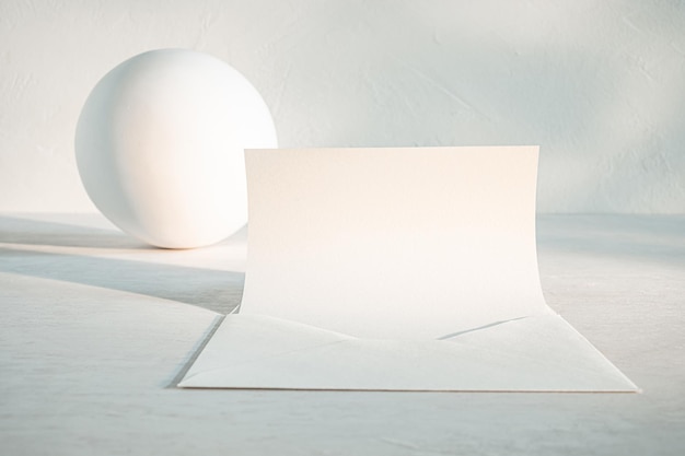 Foto wit gebogen papierblad en bol op een bleek oppervlak met zachte verlichting