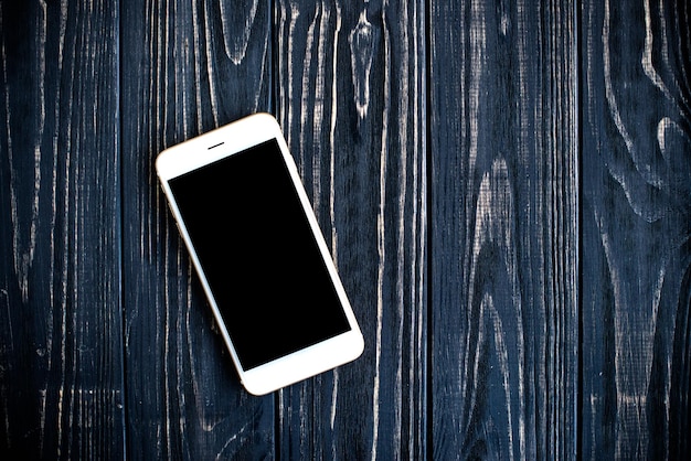 Foto wit geïsoleerd scherm smartphone mockup op zwarte houten tafel