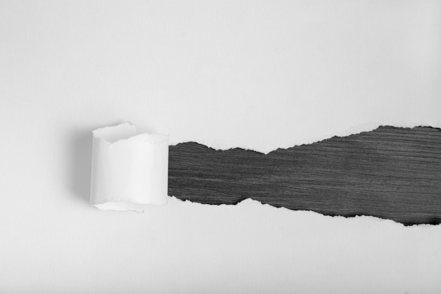 Wit gescheurd papier onder een zwarte houten achtergrond ruimte voor tekst