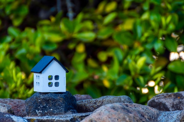 wit huis met zwart dak en ongericht groene achtergrond, voor onroerend goed, met ruimte om te plaatsen