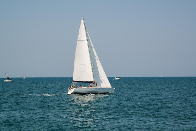 Wit jacht in de open azuurblauwe zee in de buurt van de badplaats Rimini, Italië