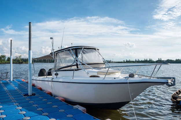 Wit jacht verankerd in rivier bij pier