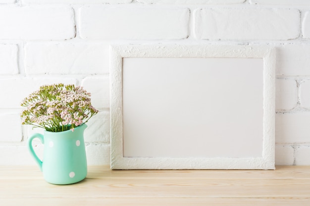 Wit landschapskadermodel met zachte roze bloemen in waterkruik