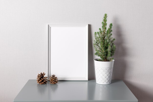 Wit leeg frame en ingemaakte kerstboom op tafel