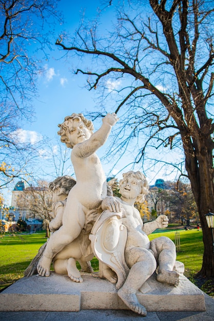 Wit marmeren standbeeld van engelachtige kinderen in het Bruggarten-park op een zonnige dag in Wenen, Oostenrijk