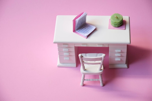 Wit miniatuur studiebureau op roze achtergrond met copyspace-weergave van bovenaf