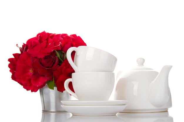 Wit servies voor thee en een boeket rozen