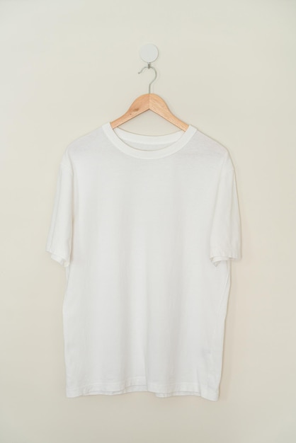 wit t-shirt hangend met houten hanger aan de muur