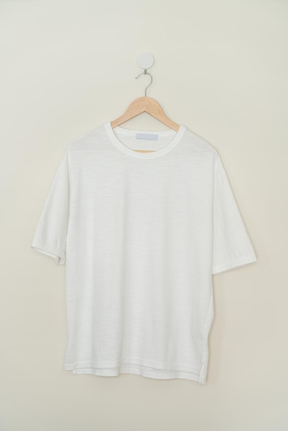 wit t-shirt hangend met houten hanger aan de muur