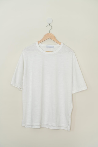 wit t-shirt hangend met houten hanger aan de muur