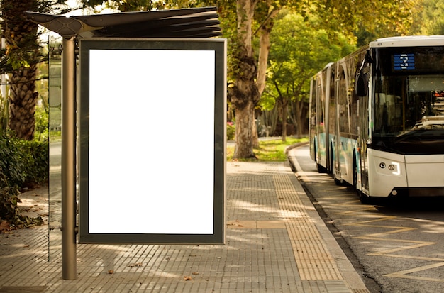 Foto wit verticaal aanplakbord, met bus op de stadsstraat