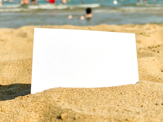 Foto wit visitekaartje ligt in het zand