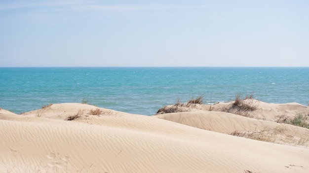 Wit zand verbergt heuvels in de buurt van blauwe zee