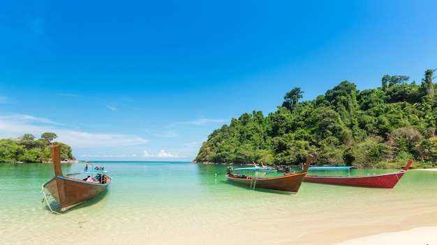 Wit zandstrand en langstaartboot op Kham-Tok Island (Koh-kam-tok