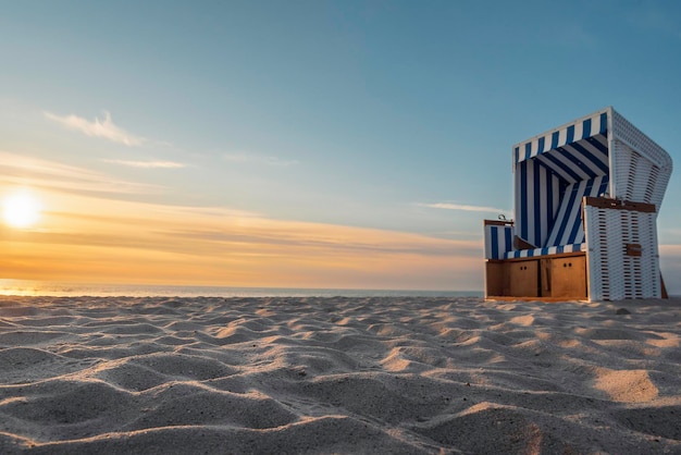 Wit zandstrand en rieten stoel op het eiland Sylt