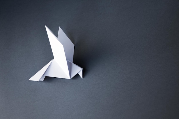 Witboek duif origami geïsoleerd op een grijze achtergrond