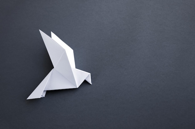 Witboek duif origami geïsoleerd op een grijze achtergrond