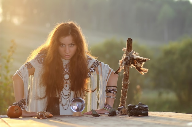 Witch with crystal ball at sunset