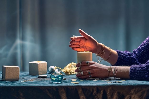 神秘的な魔法の中に魔法の呪文にキャンドルの炎を使用する魔女の女性。魔法のイラスト