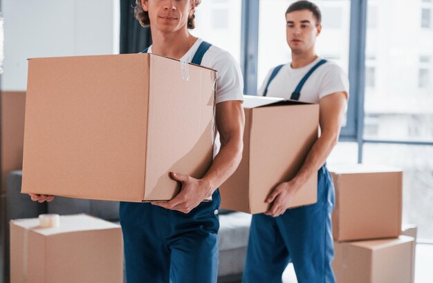 https://img.freepik.com/premium-photo/with-boxes-hands-two-young-movers-blue-uniform-working-indoors-room_146671-52141.jpg?size=626&amp;ext=jpg
