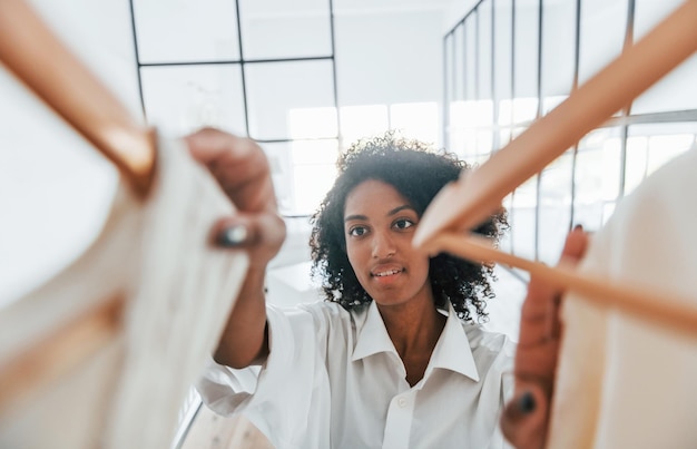 Photo with different clothes young african american woman with curly hair indoors at home