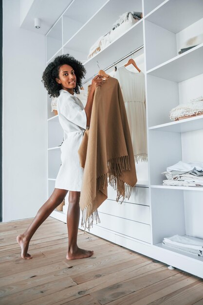 With different clothes Young african american woman with curly hair indoors at home