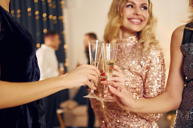 Foto con bicchieri di bevanda gruppo di persone hanno una festa di capodanno al chiuso insieme