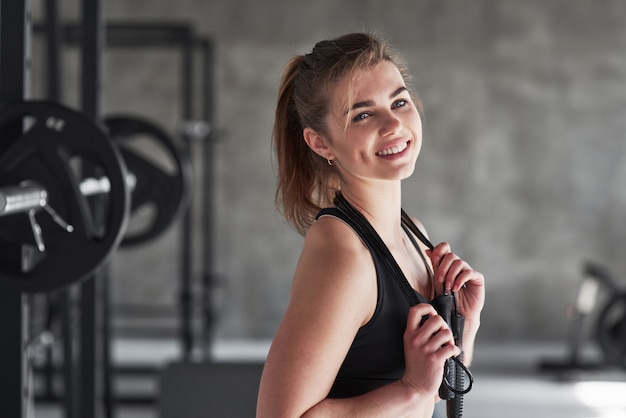 With jump rope. Photo of gorgeous blonde woman in the gym at her weekend time