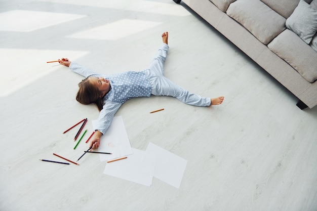 With pencils and paper Creative cute little girl indoors at home alone Child enjoying weekend