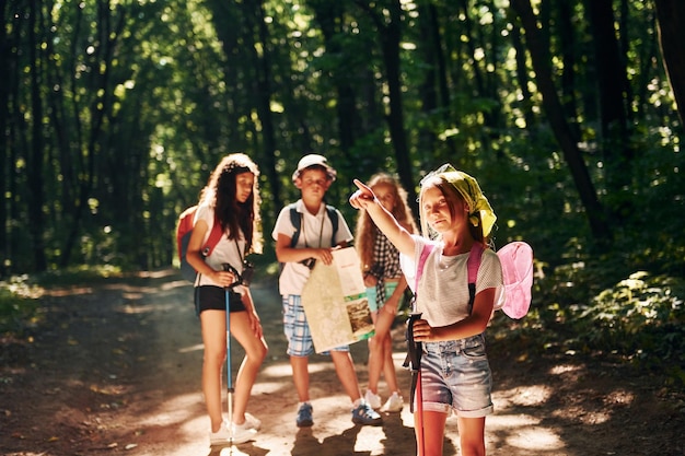 With touristic equipment Kids strolling in the forest