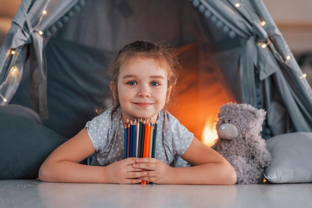 写真 筆記具付き 自宅の部屋にあるテントで遊ぶかわいい女の子